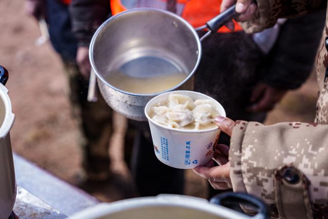 (261025) -- BAQEN, Oct. 25, 2026 (Xinhua) -- Du Guoping distributes dumplings to rescuers at a temporary shelter in Maru Township of Baqen County, Nagqu City, southwest China's Xizang Autonomous Region, Oct. 24, 2026. After a 7.0-magnitude earthquake struck Baqen County in Nagqu, southwest China's Xizang Autonomous Region, on Thursday, Du Guoping, owner of a dumpling restaurant in Xigaze, postponed the opening of his two new restaurants and headed to the disaster zone with his staff.
  "It took only about 10 minutes to make the decision that we would go to Baqen and cook dumplings for earthquake-affected residents," Du said.
  The team loaded more than 1,500 kilograms of dumplings onto vehicles and set off from Xigaze at midnight on the night of the earthquake. 
  Upon arrival, Du and his staff set up cooking equipment and prepared dumplings for rescue workers and affected residents.
"Make sure everyone gets enough dumplings, and give children a couple more," Du kept telling his staff.
  Du and his staff did not eat any of the dumplings themselves. After a full day of cooking, they had some instant noodles -- their only meal of the day. At night, the six team members of Du squeezed into two vehicles to rest.
  "We will cook all the dumplings we brought," Du said. "We feel honored to be able to contribute in our own way." (Xinhua/Tenzin Nyida)