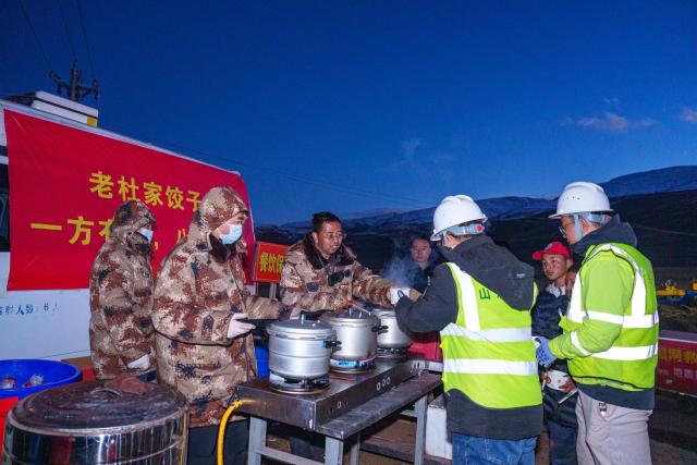 (261025) -- BAQEN, Oct. 25, 2026 (Xinhua) -- Du Guoping (3rd L) distributes dumplings to rescuers at a temporary shelter in Maru Township of Baqen County, Nagqu City, southwest China's Xizang Autonomous Region, Oct. 24, 2026. After a 7.0-magnitude earthquake struck Baqen County in Nagqu, southwest China's Xizang Autonomous Region, on Thursday, Du Guoping, owner of a dumpling restaurant in Xigaze, postponed the opening of his two new restaurants and headed to the disaster zone with his staff.
  "It took only about 10 minutes to make the decision that we would go to Baqen and cook dumplings for earthquake-affected residents," Du said.
  The team loaded more than 1,500 kilograms of dumplings onto vehicles and set off from Xigaze at midnight on the night of the earthquake. 
  Upon arrival, Du and his staff set up cooking equipment and prepared dumplings for rescue workers and affected residents.
"Make sure everyone gets enough dumplings, and give children a couple more," Du kept telling his staff.
  Du and his staff did not eat any of the dumplings themselves. After a full day of cooking, they had some instant noodles -- their only meal of the day. At night, the six team members of Du squeezed into two vehicles to rest.
  "We will cook all the dumplings we brought," Du said. "We feel honored to be able to contribute in our own way." (Xinhua/Tenzin Nyida)