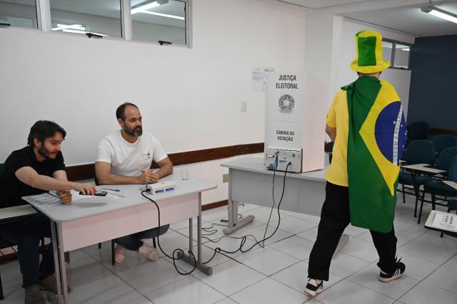 (261025) -- BRASILIA, Oct. 25, 2026 (Xinhua) -- A voter prepares to cast a ballot at a polling station in Brasilia, Brazil, Oct. 25, 2026. Voting in the second round of Brazil's 2026 presidential election officially began at 8 a.m. local time (1100 GMT) on Sunday, with polling stations across the nation set to close at 5 p.m. local time (2000 GMT).
   Incumbent President Luiz Inacio Lula da Silva of the ruling Workers' Party faces Flavio Bolsonaro, the Liberal Party candidate and son of former President Jair Bolsonaro, in the runoff after the two topped the first-round vote. (Photo by Lucio Tavora/Xinhua)