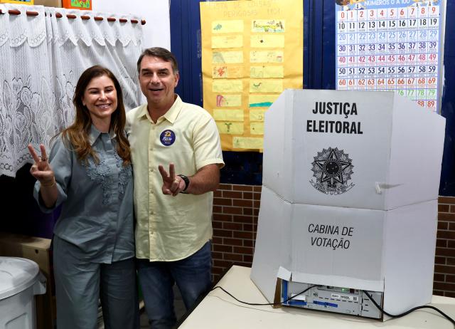 (261025) -- RIO DE JANEIRO, Oct. 25, 2026 (Xinhua) -- Flavio Bolsonaro, presidential candidate of Brazil's Liberal Party, poses for a photo with his wife after casting his ballot at a polling station in Rio de Janeiro, Brazil, Oct. 25, 2026. Voting in the second round of Brazil's 2026 presidential election officially began at 8 a.m. local time (1100 GMT) on Sunday, with polling stations across the nation set to close at 5 p.m. local time (2000 GMT).
   Incumbent President Luiz Inacio Lula da Silva of the ruling Workers' Party faces Flavio Bolsonaro, the Liberal Party candidate and son of former President Jair Bolsonaro, in the runoff after the two topped the first-round vote. (Xinhua/Jin Haoyuan)