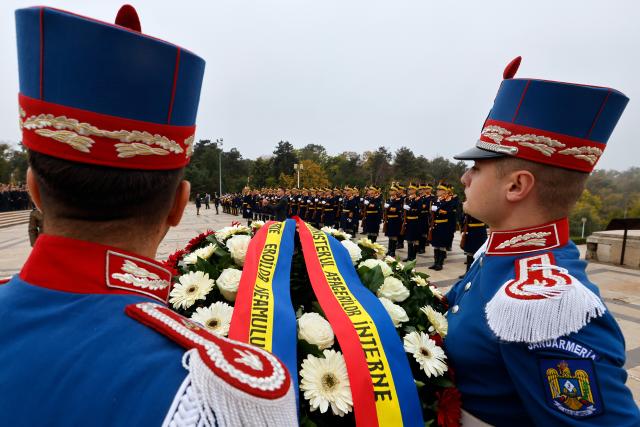(261025) -- BUCHAREST, Oct. 25, 2026 (Xinhua) -- Soldiers of an honor guard carry a flowers wreath during a ceremony marking Romania's Army Day at the Tomb of the Unknown Soldier in Bucharest in Bucharest, Romania, Oct. 25, 2026. (Photo by Cristian Cristel/Xinhua)