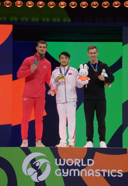 (261026) -- ROTTERDAM, Oct. 26, 2026 (Xinhua) -- Gold medalist Zou Jingyuan (C) of China, silver medalist Illia Kovtun (L) of Croatia and bronze medalist World Gymnastics 2 athlete Daniel Marinov (R) from Russia pose for a photo at the awarding ceremony for the men's parallel bars event at the Artistic Gymnastics World Championships 2026 in Rotterdam, the Netherlands, Oct. 25, 2026. (Xinhua/Weng Xinyang)