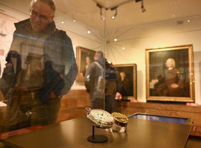 (261026) -- LONDON, Oct. 26, 2026 (Xinhua) -- A visitor looks at John Harrison's H4 marine timekeeper at the Royal Observatory in Greenwich, London, Britain, on Oct. 25, 2026. Completed in 1759, H4 helped solve the problem of determining longitude at sea through accurate timekeeping. The Royal Observatory in Greenwich was founded in 1675 to improve navigation at sea through astronomical observations and help ships determine their longitude. As the home of Greenwich Mean Time, it holds an important place in the history of astronomy, precision timekeeping and navigation. In 1884, the meridian passing through the observatory was adopted as the international Prime Meridian, establishing a common reference for measuring longitude worldwide. This historic line is still marked at the observatory today. (Xinhua/Li Mangmang)