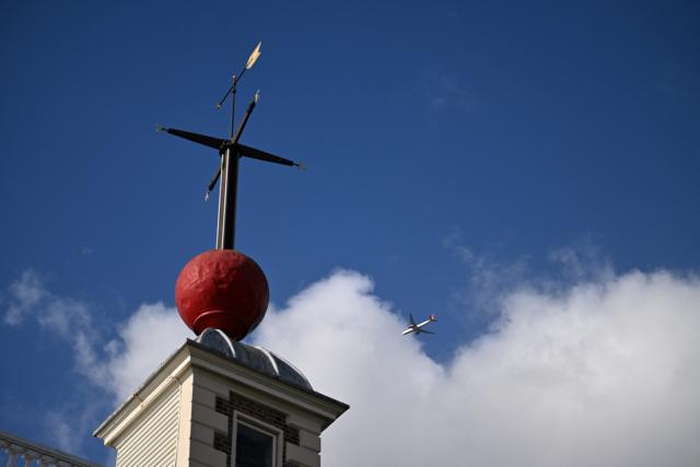 (261026) -- LONDON, Oct. 26, 2026 (Xinhua) -- The red Time Ball atop Flamsteed House at the Royal Observatory in Greenwich is seen in London, Britain, on Oct. 25, 2026. Flamsteed House was the home and workplace of John Flamsteed, Britain's first Astronomer Royal. The rooftop Time Ball began operating in 1833, dropping at a set time to help ships on the River Thames check their marine chronometers. The Royal Observatory in Greenwich was founded in 1675 to improve navigation at sea through astronomical observations and help ships determine their longitude. As the home of Greenwich Mean Time, it holds an important place in the history of astronomy, precision timekeeping and navigation. In 1884, the meridian passing through the observatory was adopted as the international Prime Meridian, establishing a common reference for measuring longitude worldwide. This historic line is still marked at the observatory today. (Xinhua/Li Mangmang)