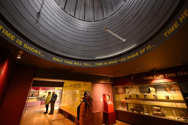 (261026) -- LONDON, Oct. 26, 2026 (Xinhua) -- A visitor views a time-themed exhibition at the Royal Observatory in Greenwich, London, Britain, on Oct. 25, 2026. The Royal Observatory in Greenwich was founded in 1675 to improve navigation at sea through astronomical observations and help ships determine their longitude. As the home of Greenwich Mean Time, it holds an important place in the history of astronomy, precision timekeeping and navigation. In 1884, the meridian passing through the observatory was adopted as the international Prime Meridian, establishing a common reference for measuring longitude worldwide. This historic line is still marked at the observatory today. (Xinhua/Li Mangmang)
