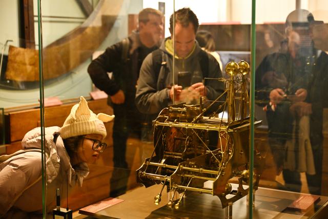 (261026) -- LONDON, Oct. 26, 2026 (Xinhua) -- A visitor views a replica of John Harrison's H1 marine timekeeper at the Royal Observatory in Greenwich, London, Britain, on Oct. 25, 2026. Completed in 1735, H1 was Harrison's first experimental marine timekeeper, designed to help solve the problem of determining longitude at sea. The Royal Observatory in Greenwich was founded in 1675 to improve navigation at sea through astronomical observations and help ships determine their longitude. As the home of Greenwich Mean Time, it holds an important place in the history of astronomy, precision timekeeping and navigation. In 1884, the meridian passing through the observatory was adopted as the international Prime Meridian, establishing a common reference for measuring longitude worldwide. This historic line is still marked at the observatory today. (Xinhua/Li Mangmang)