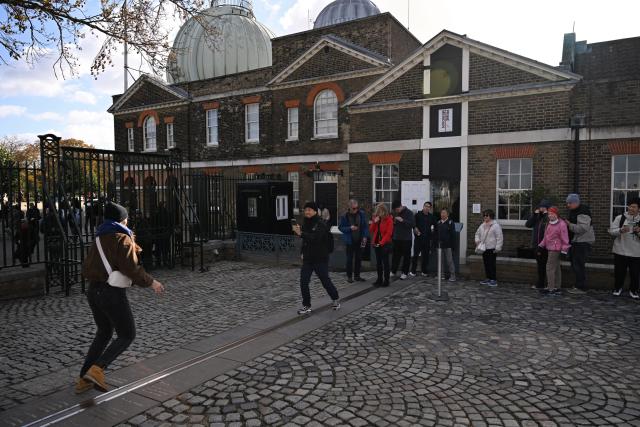 (261026) -- LONDON, Oct. 26, 2026 (Xinhua) -- Visitors queue at the historic Prime Meridian line at the Royal Observatory in Greenwich, London, Britain, on Oct. 25, 2026. The Royal Observatory in Greenwich was founded in 1675 to improve navigation at sea through astronomical observations and help ships determine their longitude. As the home of Greenwich Mean Time, it holds an important place in the history of astronomy, precision timekeeping and navigation. In 1884, the meridian passing through the observatory was adopted as the international Prime Meridian, establishing a common reference for measuring longitude worldwide. This historic line is still marked at the observatory today. (Xinhua/Li Mangmang)