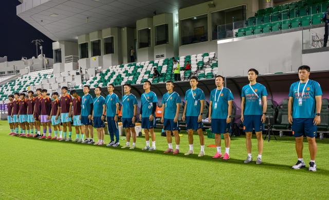 (261026) -- DOHA, Oct. 26, 2026 (Xinhua) -- China's head coach Zhang Yaokun (1st R), the team's staff and substitutes line up before the Gulf Football Federation (GFF) Gulf Cup U-17 Qatar 2026 football match between China and the United Arab Emirates in Doha, Qatar, Oct. 25, 2026. (Photo by Nikku/Xinhua)