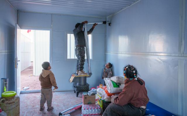 (261026) -- BAQEN, Oct. 26, 2026 (Xinhua) -- A man installs a chimney pipe in a prefabricated house at a resettlement site of a quake-hit village in Maru Township of Baqen County, Nagqu City, southwest China's Xizang Autonomous Region, Oct. 25, 2026.
  The first 60 prefabricated housing units in the earthquake zone were completed at 2:10 a.m. on Oct. 25, and electricity was connected to the units by 8 p.m. on the same day. (Xinhua/Gaesang Namgyae)
