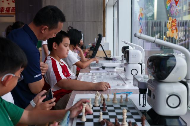 (261026) -- SHENZHEN, Oct. 26, 2026 (Xinhua) -- Children compete with AI chess robots at a community public service center in Futian District of Shenzhen, south China's Guangdong Province, Oct. 25, 2026. Shenzhen has been steadily improving the network and functions of its community public service centers since 2015, and has now built more than 4,400 such centers of various types. With each center covering a roughly one-kilometer, 15-minute walking radius, the network delivers all-age-friendly services to local residents, tourists, and foreign visitors.
   In recent years, the centers have regularly hosted a rich variety of cultural and recreational activities, and provided amenities including public reading rooms, nursery facilities and community canteens. Receiving over 400,000 visits every day across the network, they function as both convenient public service platforms and venues for community consultation and exchanges, bringing greater warmth to community-level urban governance. (Xinhua/Mao Siqian)