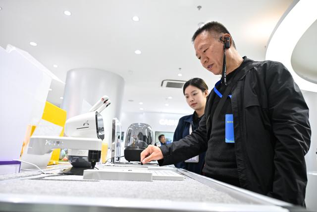 (261026) -- NANJING, Oct. 26, 2026 (Xinhua) -- A visitor plays chess with a robot at the AI Intelligent Terminal Consumption Center in the Nanjing AI Agent Distribution Center in Nanjing, east China's Jiangsu Province, Oct. 26, 2026.
  The Nanjing AI Agent Distribution Center is an integrated platform for the display and supply-demand matching of AI applications and technologies. (Xinhua/Ji Chunpeng)