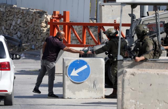 (261026) -- HEBRON, Oct. 26, 2026 (Xinhua) -- A Palestinian is seen during security checks at an Israeli checkpoint in the West Bank city of Hebron, on Oct. 26, 2026. Israeli forces launched a military operation in Hebron on Friday night. (Photo by Mamoun Wazwaz/Xinhua)