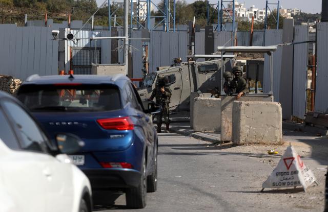 (261026) -- HEBRON, Oct. 26, 2026 (Xinhua) -- Palestinians drive through strict security checks at an Israeli checkpoint in the West Bank city of Hebron, on Oct. 26, 2026. Israeli forces launched a military operation in Hebron on Friday night. (Photo by Mamoun Wazwaz/Xinhua)