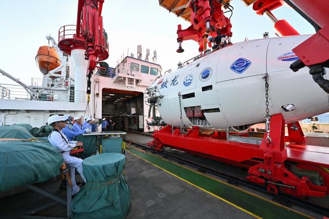 (261027) -- ABOARD RESEARCH VESSEL DEEP SEA NO. 1, Oct. 27, 2026 (Xinhua) -- Staff members make preparation before the 465th dive operation of the manned submersible Jiaolong on Oct. 2, 2026. The dive reached a depth of 7,056.9 meters. China's manned submersible Jiaolong recently completed multiple 7,000-meter dive tests and returned safely, reaching a maximum depth of 7,056.9 meters. (Xinhua/Ye Haoming)