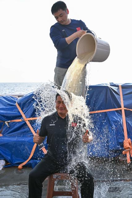 (261027) -- ABOARD RESEARCH VESSEL DEEP SEA NO. 1, Oct. 27, 2026 (Xinhua) -- Submersible pilot Qi Haibin (front) celebrates with a water splash after the manned submersible Jiaolong completed its 465th dive operation on Oct. 2, 2026. The dive reached a depth of 7,056.9 meters. China's manned submersible Jiaolong recently completed multiple 7,000-meter dive tests and returned safely, reaching a maximum depth of 7,056.9 meters. (Xinhua/Ye Haoming)