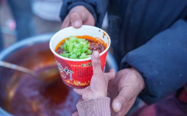 (261027) -- BAQEN, Oct. 27, 2026 (Xinhua) -- Alimjan Haliq passes a bowl of stir-fried rice noodles to a child at a temporary shelter in Maru Township of Baqen County, Nagqu City, southwest China's Xizang Autonomous Region, Oct. 26, 2026.
  In the wake of the earthquake that struck Baqen County on Oct. 22, several volunteers rushed to the quake-affected zone to serve hot meals, sending warmth to those affected who are facing high-altitude cold in late October.
   Among them was Alimjan Haliq, a volunteer from northwest China's Xinjiang. Knowing how difficult it is to cook at high altitude, he brought two pressure cookers with him all the way to the quake zone. Zhe Jiaxin, a young woman from Xinjiang, spent nearly 48 hours on a bumpy journey through multiple cities before finally reaching the epicenter. Abdu, who runs a Xinjiang restaurant in Lhasa, quickly rallied his friends, gathered supplies, and rushed to the disaster area. Their paths were different, but they converged on the snow-covered plateau for the same purpose.
   "There is strength in numbers," Alimjan Haliq said, voicing the thoughts of every volunteer. Upon arriving in the quake zone, the rows of tidy tents and prefab houses, ample supplies, and locals helping one another deeply moved the volunteers. Zhe Jiaxin said with emotion, "I want to do all I can to help the children here feel more comfortable."
   The unceasing cook fires and hot food from the volunteers did more than fill empty stomachs -- they let the affected people feel be cared and supported. (Xinhua/Tenzin Nyida)