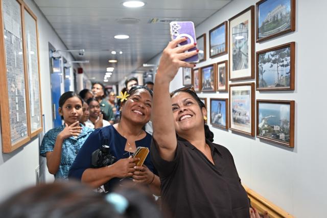 (261027) -- YAREN, Oct. 27, 2026 (Xinhua) -- Local residents take a selfie during a tour aboard China's research vessel Deep Sea No. 1 berthed at Aiwo Port in Naoero, Oct. 26, 2026.
  China's research vessel Deep Sea No. 1, carrying manned deep-sea submersible Jiaolong, on Monday visited Naoero and held an ocean-themed open day event here. (Xinhua/Li Xin)