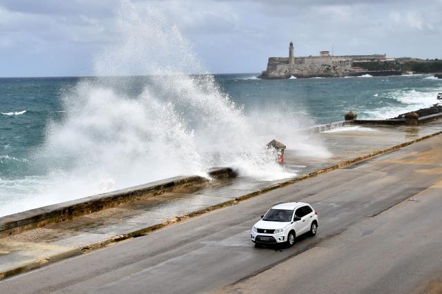 (261027) -- HAVANA, Oct. 27, 2026 (Xinhua) -- A vehicle runs along the Malecon Avenue as waves crash against the seashore in Havana, Cuba, Oct. 27, 2026. (Photo by Joaquin Hernandez/Xinhua)