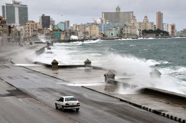 (261027) -- HAVANA, Oct. 27, 2026 (Xinhua) -- A vehicle runs along the Malecon Avenue as waves crash against the seashore in Havana, Cuba, Oct. 27, 2026. (Photo by Joaquin Hernandez/Xinhua)