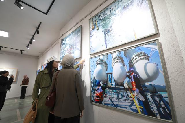 (261028) -- BISHKEK, Oct. 28, 2026 (Xinhua) -- People visit an art and photography exhibition showcasing the magnificent landscapes and diverse culture of northwest China's Xinjiang Uygur Autonomous Region in Bishkek, Kyrgyzstan, Oct. 27, 2026. The two-week exhibition opened at the Kyrgyz National Museum of Fine Arts on Tuesday, featuring 40 selected artworks and photographs about Xinjiang. (Photo by Roman/Xinhua)