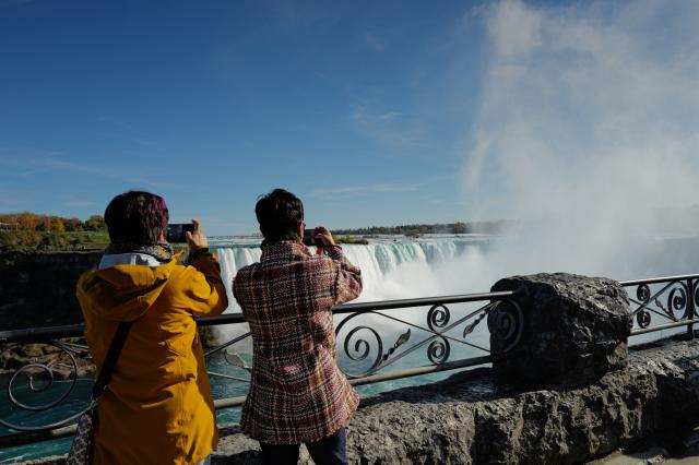 (261028) -- NIAGARA FALLS, Oct. 28, 2026 (Xinhua) -- People take photos of Niagara Falls in Ontario, Canada, Oct. 27, 2026. (Photo by Yang Shu/Xinhua)