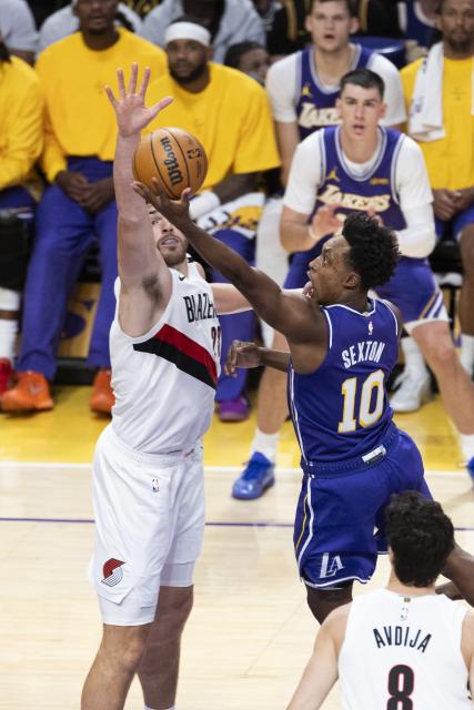 (261028) -- LOS ANGELES, Oct. 28, 2026 (Xinhua) -- Collin Sexton (R) of Los Angeles Lakers goes for a lay up against Donovan Clingan of Portland Trail Blazers during the NBA basketball game between Los Angeles Lakers and Portland Trail Blazers in Los Angeles, the United States, Oct. 27, 2026. (Photo by Ringo Chiu/Xinhua)