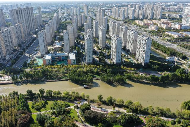 (261028) -- RUDONG, Oct. 28, 2026 (Xinhua) -- An aerial drone photo taken on Oct. 27, 2026 shows workers removing aquatic plants on the Jueju River in Rudong County of Nantong City, east China's Jiangsu Province. In recent years, Rudong County in Nantong City has made efforts to improve its aquatic ecological environment. Water environment of the three rivers, namely the Taiyun River, the Jueju River and the Juekan River, which run through the county, has undergone sound remediation. Along these waterways, the Heming Park and the bank areas of tributaries have all formed a picturesque urban landscape for people to enjoy their leisure time. (Xinhua/Ji Chunpeng)