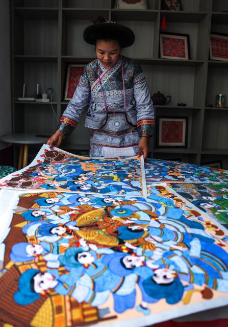 (261028) -- LIUPANSHUI, Oct. 28, 2026 (Xinhua) -- Luo Banmei, a farmer painter, displays farmers' paintings in Doujing Village of Shuicheng District in Liupanshui, southwest China's Guizhou Province, Oct. 5, 2026. In recent years, Shuicheng District has promoted its local art by offering painting training courses, establishing copyright trading platforms, and boosting the development of cultural and creative products.
   Shuicheng farmers' paintings are known for their bright, vibrant colors and exaggerated forms. These paintings bearing witness to local changes have become a cultural driver for rural revitalization. Since 2021, Shuicheng farmers' paintings have been exhibited in more than 20 countries and regions, including Britain, Japan and Australia. (Xinhua/Yang Wenbin)