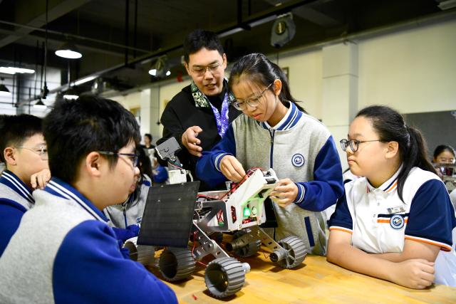 (261028) -- JINAN, Oct. 28, 2026 (Xinhua) -- A teacher guides students to learn about the principle of the lunar probe at a junior high school in Jinan, east China's Shandong Province, Oct. 27, 2026. In recent years, Jinan has strengthened science and technology education in primary and secondary schools. Through a rich array of regular sci-tech themed activities, local schools have deeply integrated scientific knowledge into daily teaching to better nurture students' scientific literacy. (Xinhua/Guo Xulei)