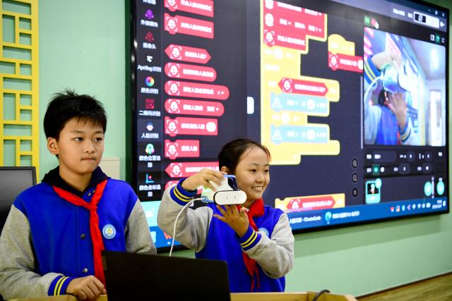 (261028) -- JINAN, Oct. 28, 2026 (Xinhua) -- Students demonstrate an AI-powered simulation system for facial recognition at a primary school in Jinan, east China's Shandong Province, Oct. 27, 2026. In recent years, Jinan has strengthened science and technology education in primary and secondary schools. Through a rich array of regular sci-tech themed activities, local schools have deeply integrated scientific knowledge into daily teaching to better nurture students' scientific literacy. (Xinhua/Guo Xulei)
