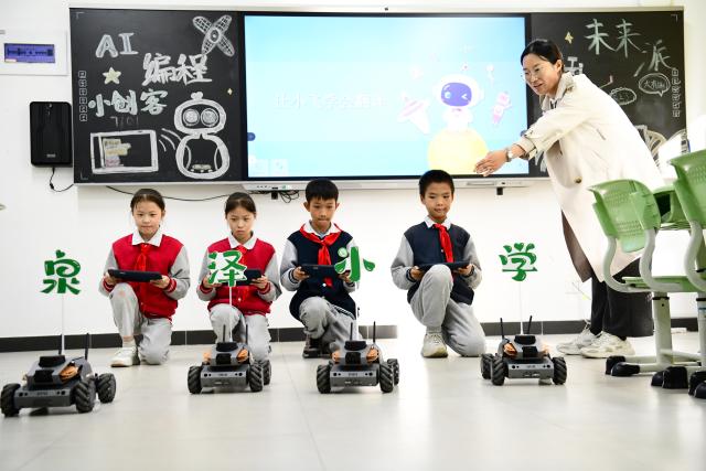 (261028) -- JINAN, Oct. 28, 2026 (Xinhua) -- A teacher guides students to train robotic vehicles at a primary school in Jinan, east China's Shandong Province, Oct. 27, 2026. In recent years, Jinan has strengthened science and technology education in primary and secondary schools. Through a rich array of regular sci-tech themed activities, local schools have deeply integrated scientific knowledge into daily teaching to better nurture students' scientific literacy. (Xinhua/Guo Xulei)