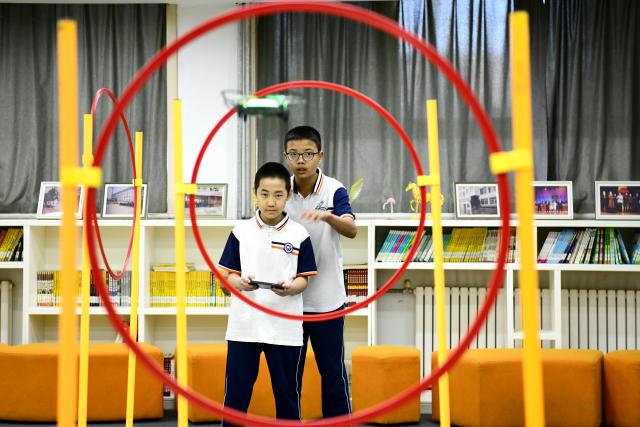 (261028) -- JINAN, Oct. 28, 2026 (Xinhua) -- Students fly a drone through obstacles at a junior high school in Jinan, east China's Shandong Province, Oct. 27, 2026. In recent years, Jinan has strengthened science and technology education in primary and secondary schools. Through a rich array of regular sci-tech themed activities, local schools have deeply integrated scientific knowledge into daily teaching to better nurture students' scientific literacy. (Xinhua/Guo Xulei)