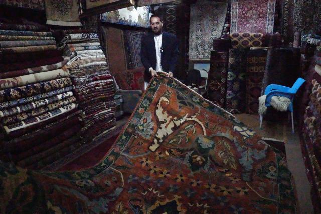 (261028) -- KABUL, Oct. 28, 2026 (Xinhua) -- Hamed Rauf, vice president of Qader Rauf Company, displays a handmade carpet that will be taken to China for the 9th China International Import Expo (CIIE) in Kabul, Afghanistan, Oct. 15, 2026. TO GO WITH "Feature: Afghan entrepreneurs look to China's annual import expo to unlock global markets" (Photo by Saifurahman Safi/Xinhua)