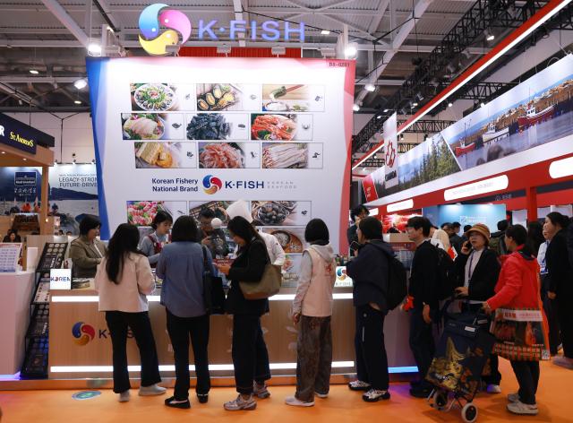 (261028) -- QINGDAO, Oct. 28, 2026 (Xinhua) -- Visitors line up for food tasting at the 29th China Fisheries & Seafood Expo in Qingdao, east China's Shandong Province, Oct. 28, 2026. The expo kicked off here on Wednesday, with an exhibition area of approximately 120,000 square meters, showcasing exhibits covering aquatic raw materials and processed products, aquaculture and processing technologies and equipment, and cold chain logistics facilities. The expo, which will last until Oct. 30, has attracted numerous domestic and international manufacturers and buyers to seek business opportunities. (Xinhua/Gao Jing)
