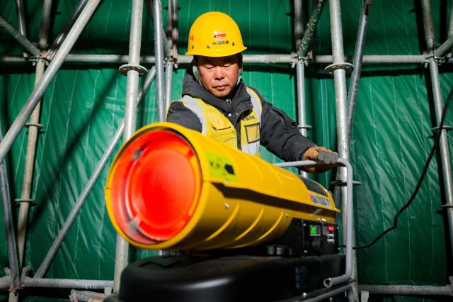 (261028) -- QIQIHAR, Oct. 28, 2026 (Xinhua) -- A worker adjusts heating facilities at a construction site of the Fuyu-Jiagedaqi Railway upgrading project in northeast China's Heilongjiang Province, Oct. 27, 2026. Various measures have been adopted to tackle difficulties in railway construction amid low temperatures, and to ensure that the project advance in an efficient and orderly manner. 
   This railway serves as a critical artery connecting the Greater Khingan Mountains and the outer world. (Xinhua/Zhang Tao)