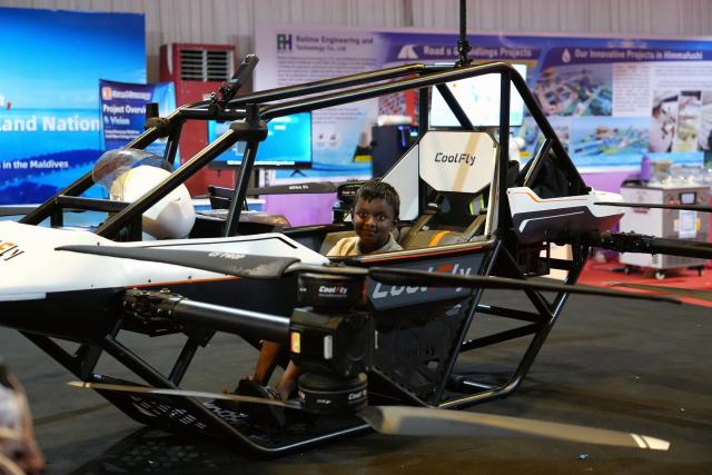 (261029) -- MALE, Oct. 29, 2026 (Xinhua) -- A teenager tries out a Chinese manned aerial vehicle at Maldives Expo 2026, in Male, Maldives, Oct. 27, 2026. The expo attracted approximately 430 exhibitors, showcasing more than 4,400 exhibits across seven themed exhibition zones. Twelve Chinese enterprises participated in the event, bringing new opportunities for Maldivian SMEs to enhance operational efficiency and expand international cooperation. (Xinhua/Xu Han)
