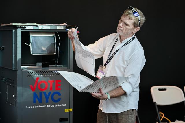 (261029) -- NEW YORK, Oct. 29, 2026 (Xinhua) -- A volunteer checks a ballot at a polling station in Queens, New York City, the United States, on Oct. 24, 2026. TO GO WITH "Feature: Rising living costs weigh on New Yorkers as midterms approach" (Photo by Ziyu Julian Zhu/Xinhua)