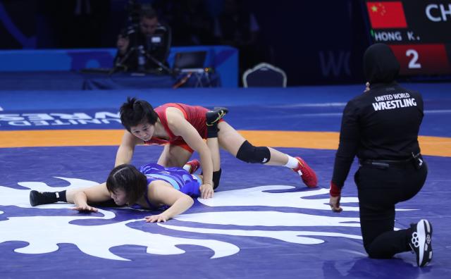 (261029) -- ASTANA, Oct. 29, 2026 (Xinhua) -- Hong Kexin (C) of China and Nagamoto Sena of Japan wrestle during the women's wrestling 57kg final at the 2026 Senior World Championships in Astana, Kazakhstan, Oct. 28, 2026. (Photo by Kalizhan Ospanov/Xinhua)