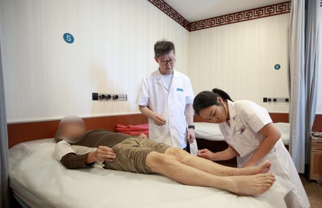 (261029) -- TIANJIN, Oct. 29, 2026 (Xinhua) -- Salocha Techawanwanitchakorn (R) performs acupuncture on a patient under the guidance of her mentor at the First Teaching Hospital of Tianjin University of Traditional Chinese Medicine (TCM) in Tianjin, north China, Sept. 10, 2026. TO GO WITH "Feature: Thai medical student finds a calling in acupuncture" (Xinhua/Liu Runzhi)