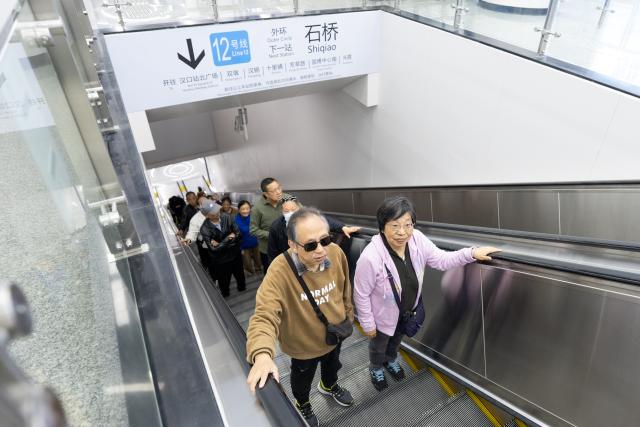 (261029) -- WUHAN, Oct. 29, 2026 (Xinhua) -- People take an escalator at a station of the Wuhan Metro Line 12 in Wuhan, central China's Hubei Province, Oct. 29, 2026.
  China's longest subway loop line, the Wuhan Metro Line 12, started full line operation on Thursday. The 59.9-km line has 37 stations and stretches across seven administrative districts of the city. 
  By far, the total mileage of Wuhan Metro in operation has exceeded 581 kilometers. (Xinhua/Xiao Yijiu)