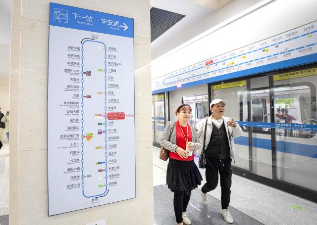 (261029) -- WUHAN, Oct. 29, 2026 (Xinhua) -- People take a train of the Wuhan Metro Line 12 in Wuhan, central China's Hubei Province, Oct. 29, 2026.
  China's longest subway loop line, the Wuhan Metro Line 12, started full line operation on Thursday. The 59.9-km line has 37 stations and stretches across seven administrative districts of the city. 
  By far, the total mileage of Wuhan Metro in operation has exceeded 581 kilometers. (Xinhua/Xiao Yijiu)