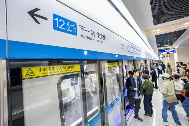 (261029) -- WUHAN, Oct. 29, 2026 (Xinhua) -- People take a train of the Wuhan Metro Line 12 in Wuhan, central China's Hubei Province, Oct. 29, 2026.
  China's longest subway loop line, the Wuhan Metro Line 12, started full line operation on Thursday. The 59.9-km line has 37 stations and stretches across seven administrative districts of the city. 
  By far, the total mileage of Wuhan Metro in operation has exceeded 581 kilometers. (Xinhua/Xiao Yijiu)