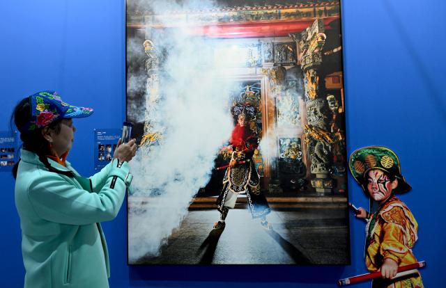 (261029) -- SANMENXIA, Oct. 29, 2026 (Xinhua) -- A visitor takes photos at an exhibition during the 16th China Photography Festival in Sanmenxia City, central China's Henan Province, Oct. 29, 2026. The 16th China Photography Festival kicked off here on Thursday, featuring exhibitions covering a variety of themes, including documentary and art. (Xinhua/Zhu Xiang)