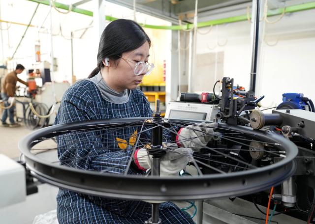 (261029) -- TANGSHAN, Oct. 29, 2026 (Xinhua) -- A staff member operates at the workshop of a bicycle enterprise in Lutai economic development zone of Tangshan City, north China's Hebei Province, Oct. 28, 2026. In recent years, Lutai economic development zone in Tangshan City has continuously promoted the upgrading of its bicycle industry. Local manufacturers are encouraged to expand their operation from mere production of components to development and production of ready-for-use bicycles. There are 55 of such manufacturers in this district, covering production of bicycles, bicycle parts, and motors for electric two-wheelers. (Xinhua/Yang Shiyao)