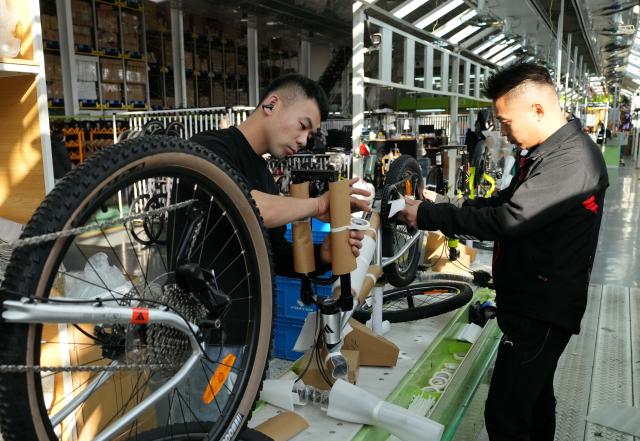 (261029) -- TANGSHAN, Oct. 29, 2026 (Xinhua) -- Staff members operate at the workshop of a bicycle enterprise in Lutai economic development zone of Tangshan City, north China's Hebei Province, Oct. 28, 2026. In recent years, Lutai economic development zone in Tangshan City has continuously promoted the upgrading of its bicycle industry. Local manufacturers are encouraged to expand their operation from mere production of components to development and production of ready-for-use bicycles. There are 55 of such manufacturers in this district, covering production of bicycles, bicycle parts, and motors for electric two-wheelers. (Xinhua/Yang Shiyao)