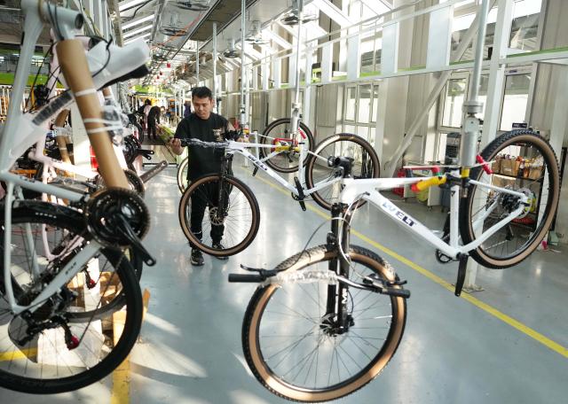 (261029) -- TANGSHAN, Oct. 29, 2026 (Xinhua) -- A staff member operates at the workshop of a bicycle enterprise in Lutai economic development zone of Tangshan City, north China's Hebei Province, Oct. 28, 2026. In recent years, Lutai economic development zone in Tangshan City has continuously promoted the upgrading of its bicycle industry. Local manufacturers are encouraged to expand their operation from mere production of components to development and production of ready-for-use bicycles. There are 55 of such manufacturers in this district, covering production of bicycles, bicycle parts, and motors for electric two-wheelers. (Xinhua/Yang Shiyao)