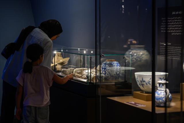(261029) -- DOHA, Oct. 29, 2026 (Xinhua) -- Visitors view ceramic artifacts at the exhibition "Boats Floating Afar: The Maritime Trade of Ancient Chinese Ceramics" at the National Museum of Qatar in Doha, Qatar, Oct. 29, 2026. (Photo by Nikku/Xinhua)