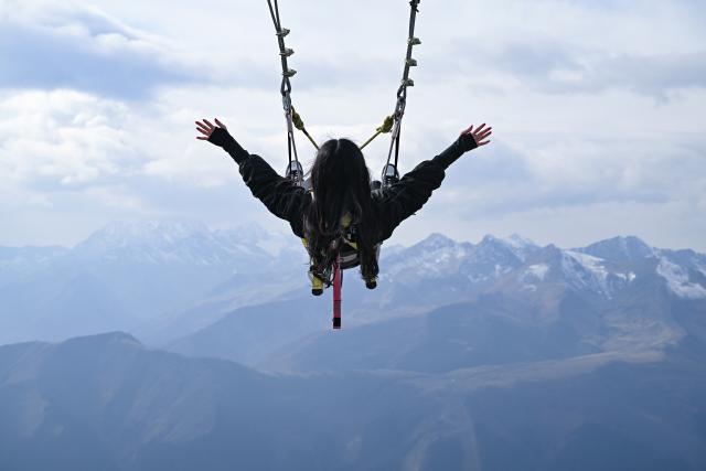 (261030) -- CHERKESSK, Oct. 30, 2026 (Xinhua) -- A tourist experiences an alpine swing in the Arkhyz resort area in the Karachay-Cherkessia Republic, Russia, Oct. 29, 2026. Arkhyz is a mountain village and a well-known tourist resort at the foot of the Greater Caucasus Mountains in the Karachay-Cherkessia Republic in southern Russia. (Xinhua/Feng Kaihua)