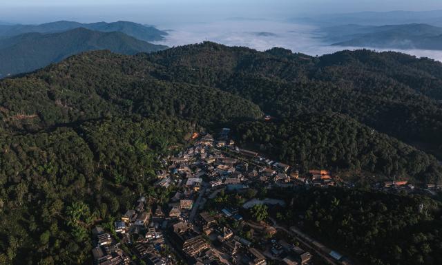 (261030) -- PU'ER, Oct. 30, 2026 (Xinhua) -- An aerial drone photo taken on Oct. 30, 2026 shows a view of Nuogan Village nestled in Jingmai Mountain, in Lancang Lahu Autonomous County of Pu'er City, southwest China's Yunnan Province. (Xinhua/Wang Guansen)