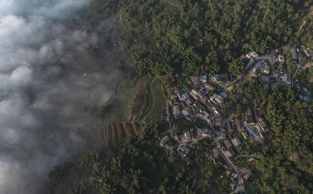 (261030) -- PU'ER, Oct. 30, 2026 (Xinhua) -- An aerial drone photo taken on Oct. 30, 2026 shows a view of a village nestled in Jingmai Mountain, in Lancang Lahu Autonomous County of Pu'er City, southwest China's Yunnan Province. (Xinhua/Wang Guansen)